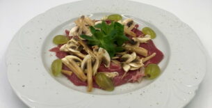 Carpaccio di manzo con funghi champignon e uva bianca